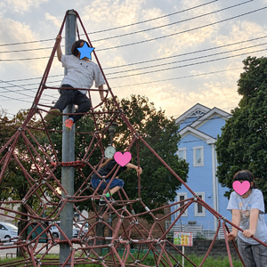 夕暮れのロープ遊具と子どもたち