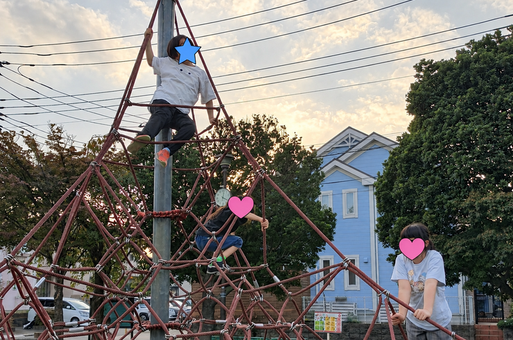 夕暮れのロープ遊具と子どもたち